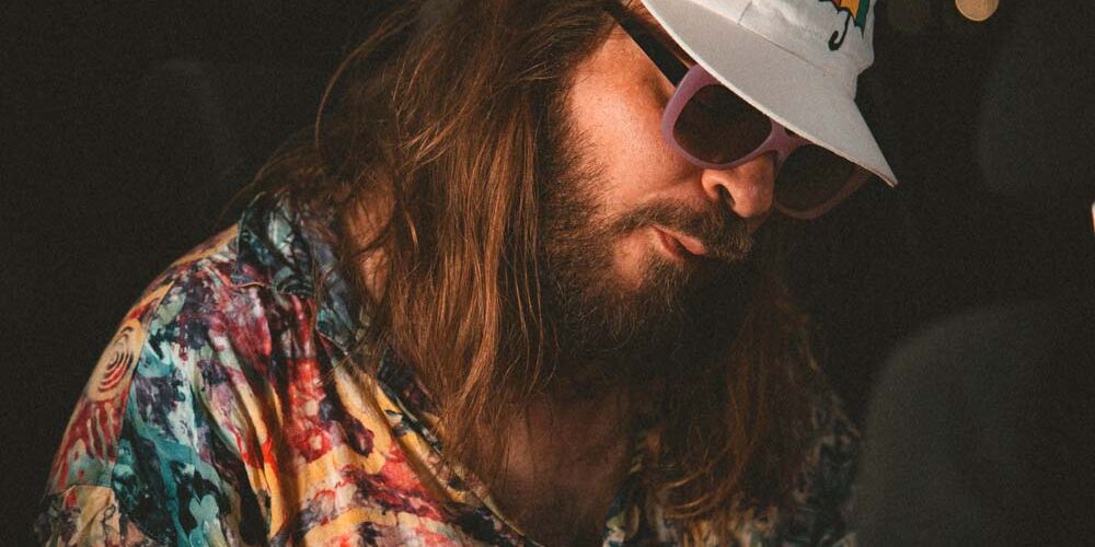 230425_OnkLou_PhilipPesic3-2 One Lou in buntem Hemd mit weißer Kappe und Sonnenbrille